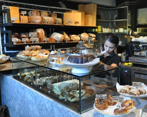 A food attendant piles the food display at The Abaca Baking Company Cafe & Coffee in this March 2015 photo. (CDN FILE PHOTO)