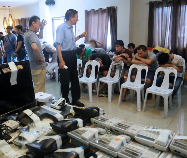 A representative of the Embassy of Taiwan (standing) checks on the 68 Taiwanese and Chinese nationals who were arrested in operations of a syndicate engaged in the cybercrime fraud. The suspects are detained in Camp Sergio Osmena where an inventory is being made of telephones, computers and other gadgets seized from houses and condominium units in Cebu City where they operated. (CDN PHOTO/ JUNJIE MENDOZA)