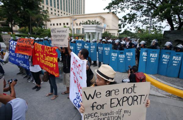 More than 50 anti-riot police block the perimeter fence of Radisson Blu, one of the venues of the Asia-Pacific Economic Cooperation (APEC) meetings in Cebu, as more than 20 student activists hold a five-minute protest. (CDN PHOTO/ JUNJIE MENDOZA)
