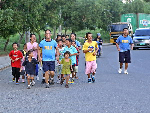 Chief Insp. Michael Bastes and other policemen of Mandaue City jog with street children on Tuesdays and Thursdays. They go to the church to pray, then have supper together at the social welfare office. (CDN PHOTO/LITO TECSON)