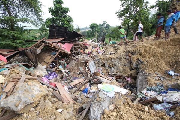 Residents of sitio Kalubihan of the neighboring barangay Casili in Mandaue City look at what remained of the rented house where Vicente Cariquitan, Jr. died after being buries in the rubble for hours. (CDN PHOTO/ JUNJIE MENDOZA)