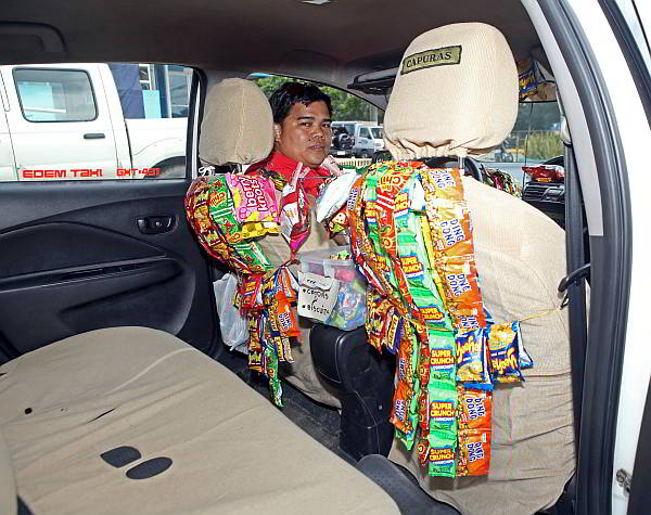 An assortment of snacks greet passengers of taxi driver Adones Mejasco.  (CDN Photo/Lito Tecson)