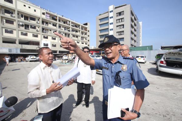 Senior Supt. Mariano Natu-el (right), chief of the Mandaue City Police Office (MCPO), is confronted by Alfredo Aton, who claimed to be the owner of a lot in barangay Subangdaku where two taxi operators were ordered to vacate. (CDN PHOTO/ JUNJIE MENDOZA)