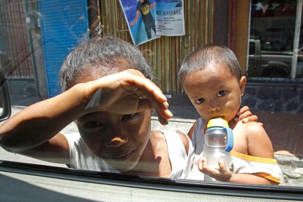 Children knock on windows and peer into passing cars to beg for coins from motorists on General Maxilom Avenue, a familiar sight. Some go farther to dull their hunger pangs by sniffing Rugby. (CDN FILE PHOTO)