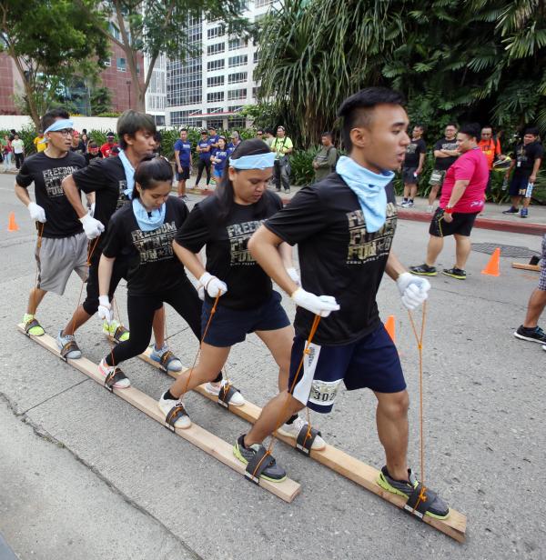 TEST OF TEAMWORK. Reporters of Cebu Daily News walk in unison on two planks of wood as part of the Metafit Boot Camp in Cebu Business Park. (CDN PHOTO/ JUNJIE MENDOZA)