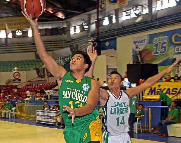 Lyder Canieso of the USC Baby Warriors eludes the defense of UV’s Ramish Alforque to convert a layup in the secondary division of the Cesafi basketball tournament yesterday at the Cebu Coliseum. (CDN PHOTO/LITO TECSON)