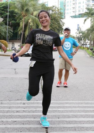 Cebu Daily News' Grace Morallas smiles as she reaches the finish line first to top the 3K division. (CDN PHOTO/ JUNJIE MENDOZA)