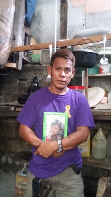 Edmundo Bureros holds a photo of his son who was killed after he got toppled down by an electric post in barangay Tinago. (CDN PHOTO APPLE MAE TA-AS)