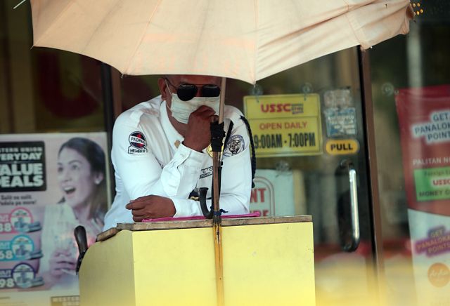 A security guard wears a mask while manning his post. The air quality in Metro Cebu has improved, but officials are still encouraging those with lung and heart problems to wear masks. (CDN PHOTO/TONEE DESPOJO)