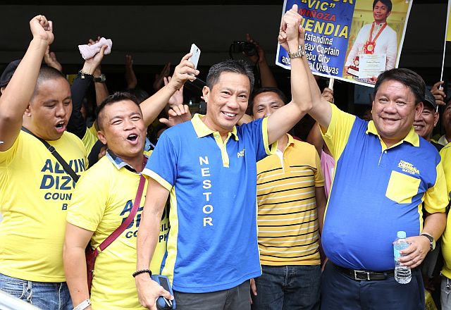 BOPK FILE THEIR COC'S/OCT. 15, 2015: BOPK mayoralty candidate Tomas Osmeña and his Vice mayoralty candidate Nester Archival rais their hands before their supporters outside the Comelec office after filling their Certificate of Candidacies.(CDN PHOTO/JUNJIE MENDOZA)