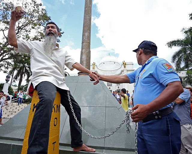 ERVIN GALLO OLIVEROS TIED HIMSELF CAPITOL FLAG POLE/OCT.06,2015:Ervin Gallo Oliveros talk to people who witness after he tied himself at Capitol flag pole while PO3 Eugene Amanence of Provicial Police detail at Capitol accompany him.(CDN PHOTO/LITO TECSON)