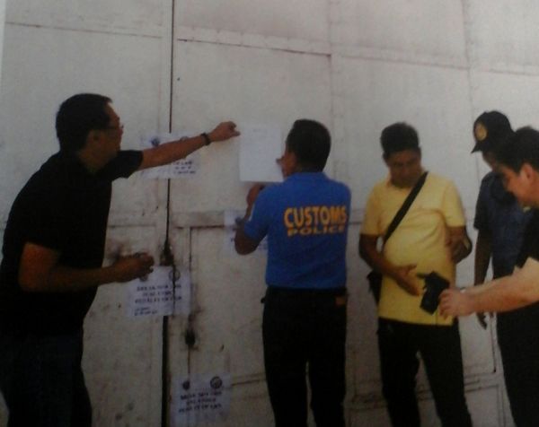 Customs officers of the Port of Cebu seal a warehouse in Mandaue City after they discover that 15 container vans were illegally withdrawn from the Cebu International Port. (CDN Photo Michelle Joy L. Padayhag)