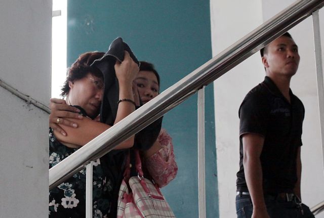OFF TO CHINA/OCT. 23, 2015: Plain cloths Policewoman (center) escorted arrested Chinese consulate staff Gou Jing (left) who cover her face from TV cameramen and Press photographers as she arrived in Camp Sergio Osmeña where a Chinese Ambassador and about 20 Chinese police officers were waiting to escort her and her husband Li Qing Liang to China.(CDN PHOTO/JUNJIE MENDOZA)