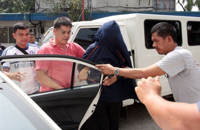 OFF TO CHINA/OCT. 23, 2015: Plain cloths Police officer's escorted arested Chinese consulate staff Li Qing Liang who cover his face from TV cameramen and Press photographers as he is about to board a waiting police mobile car in Cebu City Police Office (CCPO) to brought him at Camp Sergio Osmeña where a Chinese Ambassador and about 20 Chinese police officers were waiting to escort him and his wife Gou Jing to China.(CDN PHOTO/JUNJIE MENDOZA)
