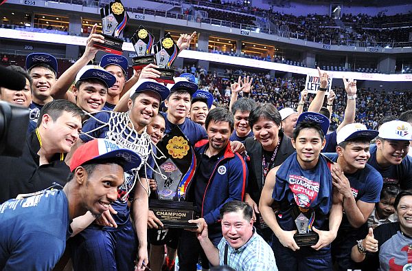 The Letran Knights celebrate with team manager Manny Pacquio after they win this year's championship of the NCAA men's basketball tournament. The Knights defeated the San Beda Red Lions in overtime, 85-82, to win their first crown in 10 years.