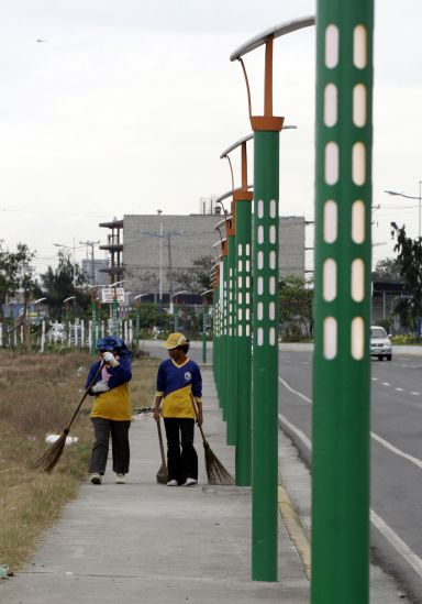 NOW GONE. Scavengers pass through a column of the controversial lampposts installed along the sidewalk of the streets in North Reclamation Area, Mandaue City in this photo taken on Feb. 4, 2009. The lampposts have since disappeared. (CDN FILE PHOTO)