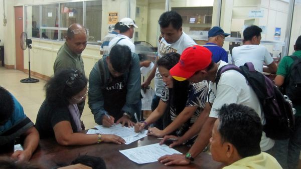 Employees of El Nuevo Bantay Radyo fill up the complaint forms at the National Labor Relations Commisson to press for unpaid wages and separation pay since the radio stations went off the air on Aug. 1. (CDN PHOTO/ADOR MAYOL)