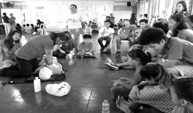 April Estopa of Red Cross demonstrates first aid techniques to participants of the Children’s Month celebration at the Don Bosco Youth Center in Pasil, Cebu City.