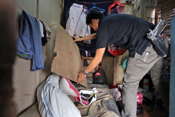 An NBI-7 agent inspects one of the rented rooms of a drug den across the street from Cebu City Hall during the raid. (CDN PHOTO/JUNJIE MENDOZA)
