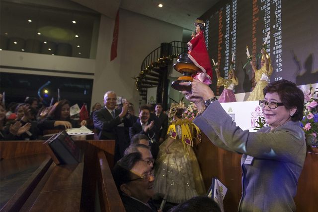 Margaret Gsaisano-Ang holds up the image of Sto. Nino, Cebu's patron, at the Philippine Stock Exchange in Makati as Sinulog dancers perform a dance offering on stage for a touch of Cebuano culture. (CDN PHOTO/TONEE DESPOJO)