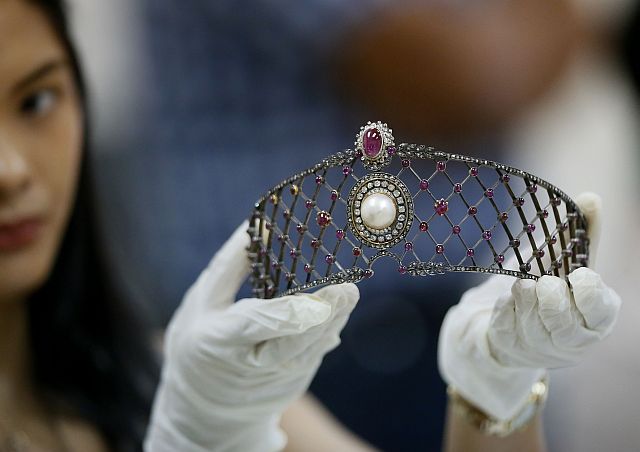 Katrina Camille Pena of the Presidential Commission on Good Government holds a set of jewelry from the so-called Hawaii Collection, one of three sets of the Marcos Jewelry Collection, during appraisal by Sotheby's at the Central Bank of the Philippines. (AP PHOTO)