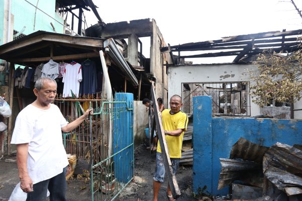 Alberto Caballero (left) checks what is left of his house after a fire that hit sitio Baca, barangay Apas early morning on All Saints' Day. (CDN PHOTO/JUNJIE MENDOZA)