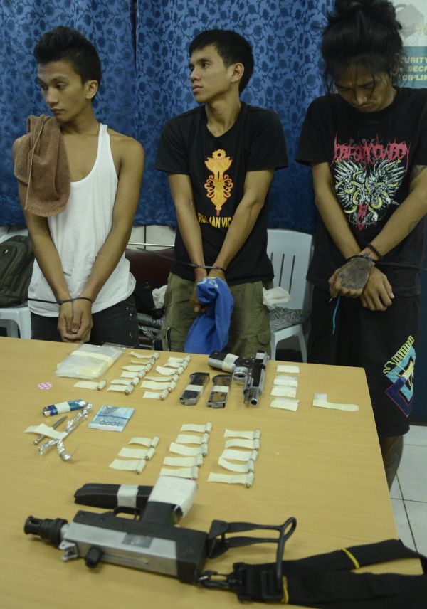 Three of the suspects nabbed in the operation, along with assorted drug packets, money bills and guns. (CDN PHOTO/CHRISTIAN MANINGO)