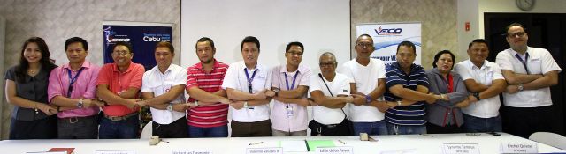 Officials and representatives from the Visayan Electric Co. and telecommunication firms in Cebu link arms to show their solidarity after signing the emergency response guidelines. (CDN PHOTO/TONEE DESPOJO)