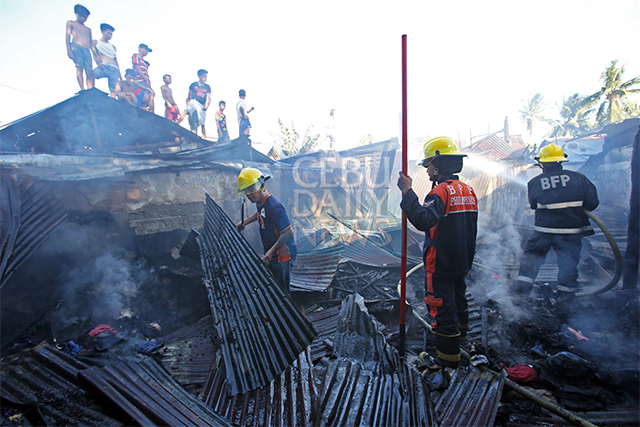 Talisay City firefighters douse the remaining flames that destroyed the house of resident Matthew Layese of sitio Salvador barangay Tanke. (CDN PHOTO/JUNJIE MENDOZA)
