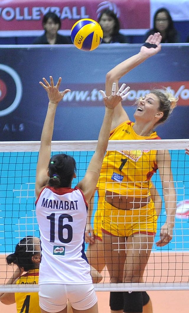 Import Alexis Olgard of Philips Gold goes for a kill against the defense of Petron’s Dindin Santiago Manabat. (INQUIRER)