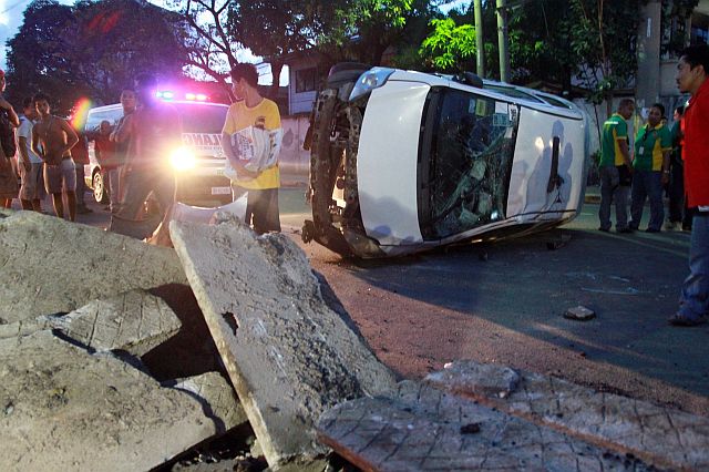 EARLY MORNING VEHICULAR ACCIDENT/NOV. 14, 2015: A Tiger Taxi lays on its side after it hits a concrete as center island (left) that is removed on Gen. Maxilom Ave. barangay Carreta across DSWD regional office that injured taxi driver Manuel Jose Rubia Echaves and his woman passenger early morning yesterday.(CDN PHOTO/JUNJIE MENDOZA)