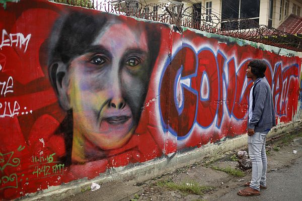 A man looks at a graffiti congratulating Myanmar's opposition leader Aung San Suu Kyi and her party's election victory in Mandalay, Myanmar. (AP Photo)