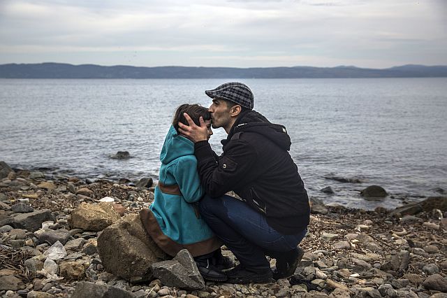 A Syrian man kisses his daughter shortly after disembarking from a dinghy at a beach on the Greek island of Lesbos after crossing the Aegean sea from the Turkish coast on Monday. (AP PHOTO)