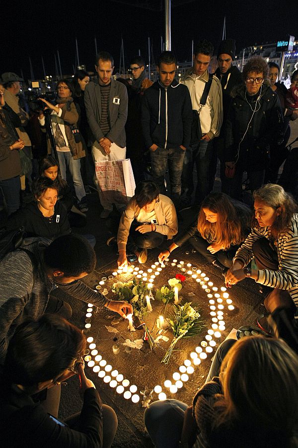 People light candles in the shape of a heart, on the Old-Port in Marseille, southern France, after the Paris attacks on Friday. (AP Photo)