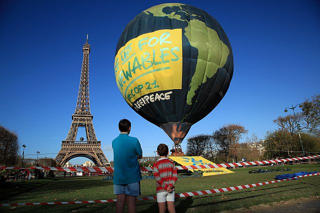 BBoys look at a hot air balloon of the environmental group Greenpeace, near the Eiffel Tower ahead of the 2015 Paris Climate Conference in Paris, which starts today, Nov. 30. (AP PHOTO)