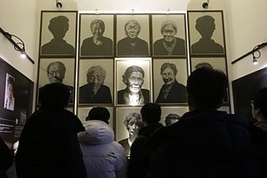South Korea high school students look at portraits of "sex salves" who were forced to serve for the Japanese Army during World War II at the House of Sharing, the home for the living sex slaves, in Gwangju, South Korea. (AP PHOTO)