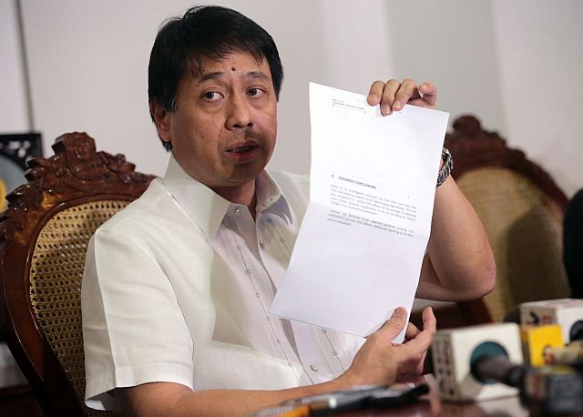 Justice Undersecretary Emmanuel Caparas shows the report of the NBI on the laglag bala scheme. (INQUIRER PHOTO)
