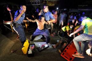 STABBING ON CHRISTMAS EVE./DEC. 25, 2015: Responding police officers of the Mobile Patrol Group (MPG) try to hold a relative who tries to approach Ivan Sollano of Sambag 2 that is being attended by paramedics by applying CPR after he was alledgely stabbed by unidentified person at Private road corner V Rama Ave. barangay Sambag 1 last Christmas Eve.dec. 25, 2015 celebration.(CDN PHOTO/JUNJIE MENDOZA)
