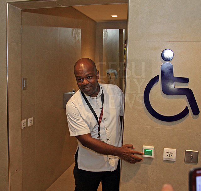 Andrew Acquaah Harrison, chief executive advisor of GMR-Megawide Cebu Airport Corp., shows newly renovated restroom for persons with disabilities at the Mactan International Airport during a media tour. (CDN PHOTO/LITO TECSON)