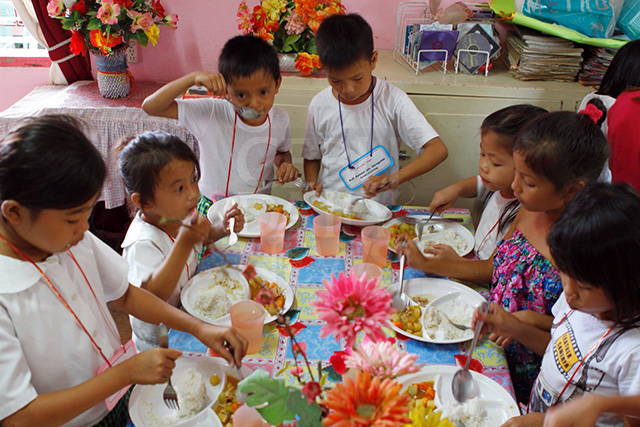 Students of Umapad Elementary School in Mandaue City enjoy a free meal from Jollibee in this file photo. Government has its own program as part of efforts to improve the nutritional status of children. 