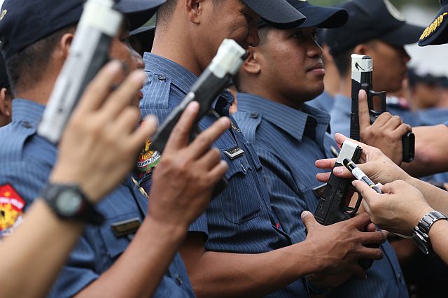 Policemen seal the muzzles of their firearms to show commitment to its fight against indiscriminate firing during Christmas and the New Year revelry. (INQUIRER PHOTO)
