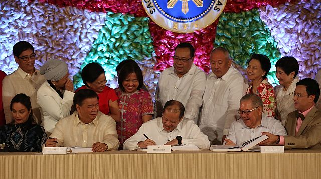 President Aquino signs the P3.002-trillion budget for 2016, during the Presidential Enactment Ceremony at the Malacañang Palace. (INQUIRER PHOTO)