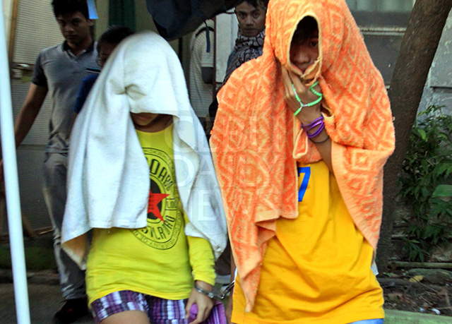 The couple covers their faces with towels after leaving the Cebu Provincial Prosecutor's Office where they underwent preliminary investigation. (CDN PHOTO/LITO TECSON)