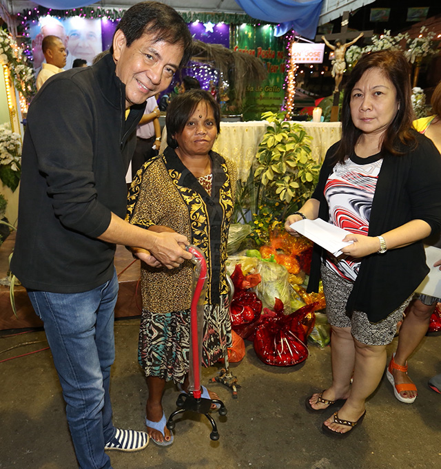 Suspended Cebu City Mayor Michael Rama hands over a new cane to Lilibeth Ponsika donated by the Department of Social Welfare Services (DSWS) headed by Dr. Ester Concha (right) after the Simbang Gabi in Carbon market. (CDN PHOTO/JUNJIE MENDOZA)