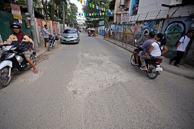 SILOYS WATCHING APAS ROAD/DEC.01,2015:Motorist pass the delapedated road of Barangay Apas the pots hole is of the many potholes in the area.Attention any government on these.(CDN PHOTO/LITO TECSON)