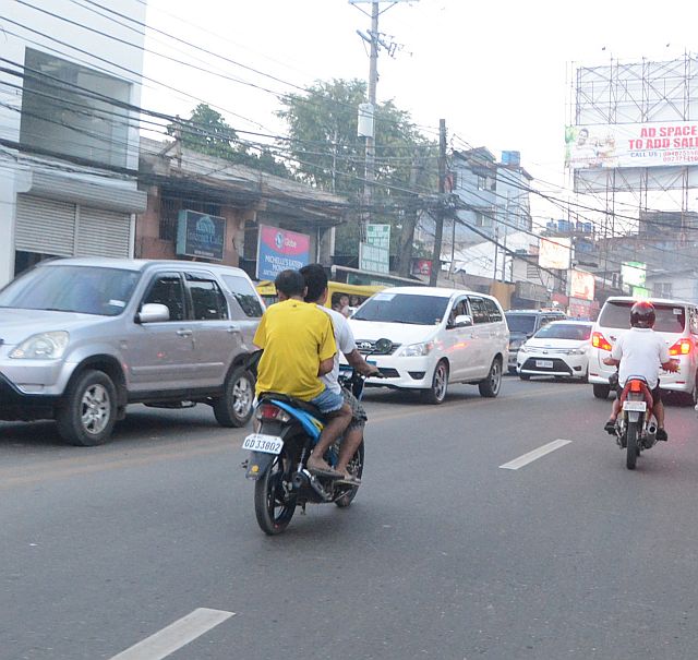 SILOY IS WATCHING/DEC. 13, 2015 A tandem riding a motorcyle without crash helmets in Lahug, Cebu City. (CDN PHOTO/CHRISTIAN MANINGO)