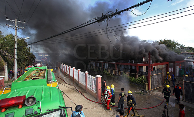 Thick smoke billows from the building that was razed by fire in barangay Opao, Mandaue City yesterday morning. (CDN PHOTO/JUNJIE MENDOZA)