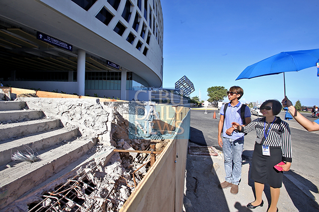Sherry Tuvilla (right), Visayas regional operations manager for SM Supermalls, shows CDN reporter Jose Santino Bunachita unfinished concrete stairs in the Seaside View wing of the mall. Construction was stopped for a redesign after the DPWH said it exceeds a required 8-meter setback. (CDN PHOTO/JUNJIE MENDOZA)