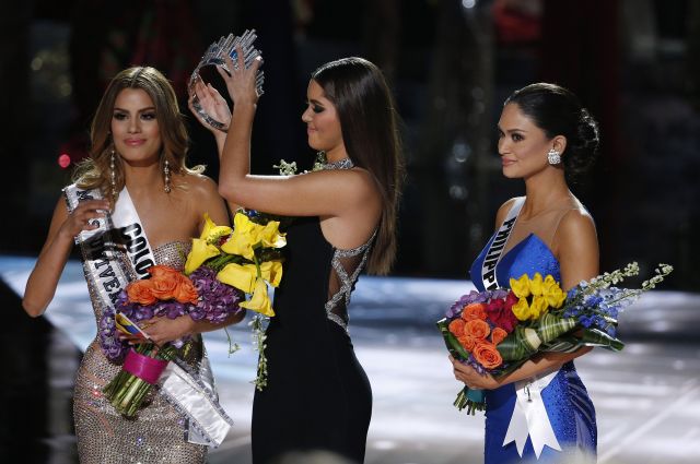 Former Miss Universe Paulina Vega (center) removes the crown from Miss Colombia Ariadna Gutierrez (left) before giving it to Miss Philippines Pia Alonzo Wurtzbach (right). The pageant host  apologized for misreading the contest results. (AP Photo/John Locher)
