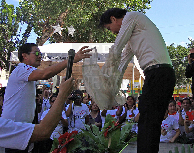 To show that "I am and ordinary person just like you", suspended Mayor Michael Rama removes his barong tagalog before supporters outside City Hall during a program after an outdoor Mass. (CDN PHOTO/TONEE DESPOJO)